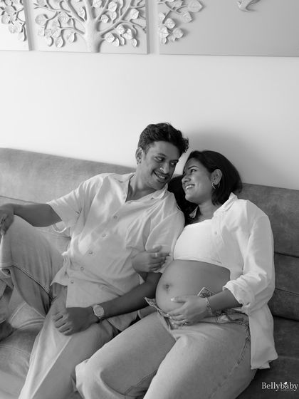 There's a special comfort in being at home. This black and white portrait captures a relaxed, happy moment between the couple on their own sofa.