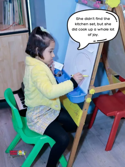 A quiet moment of creativity at the drawing easel. Our play area also has spots for kids who love art and drawing.