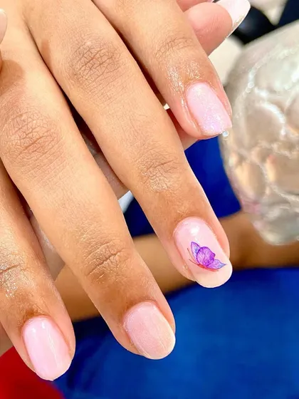The hottest minimal butterfly nails. A single, delicate purple butterfly adds a touch of magic to this clean and simple manicure.