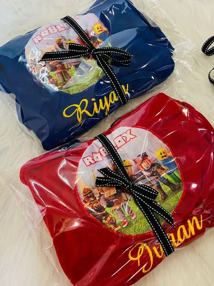 Our personalised Roblox bathrobes, wrapped and ready to go as awesome birthday return gifts. We have them in both red and blue.