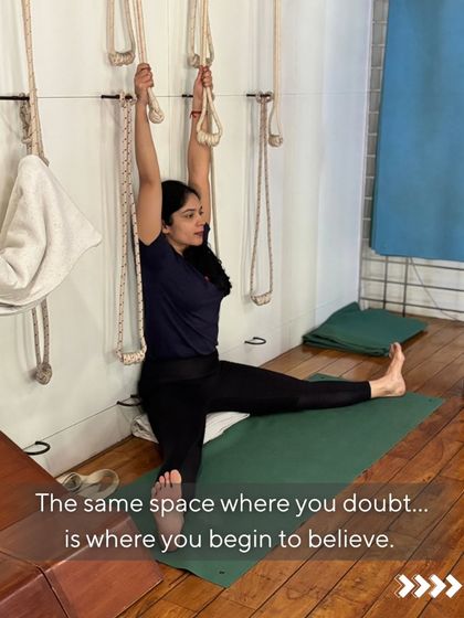 Courage is not the absence of fear; it is moving with it. The body remembers trauma and doubt. Here, a student uses the rope wall to work on a split, a pose that requires both flexibility and mental fortitude. We move through the fear with breath and intention.