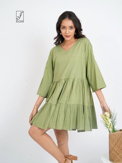 A pose that highlights the dress's details, with the model holding a bouquet of flowers.