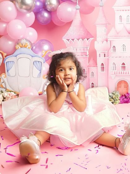A sweet pose from a little princess, sitting amongst the confetti and presents in her pink fairytale world.