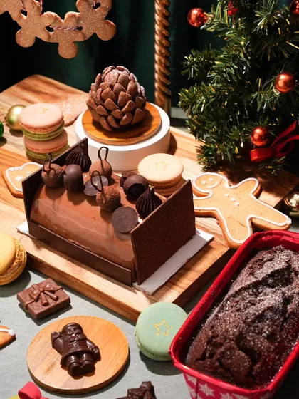 A festive flat lay showcasing an entire Christmas dessert collection. I arranged a yule log, gingerbread cookies, macarons, and chocolate treats to create a feeling of abundance and holiday cheer.