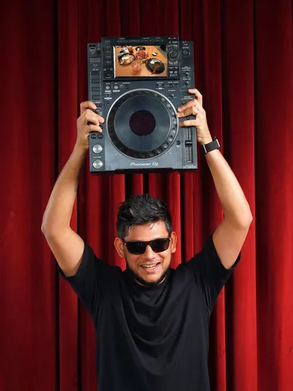A playful shot of me holding up a CDJ player, showing my fun side and love for the gear.