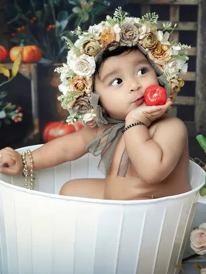 This little one is having a great time in the tub, holding a toy apple. Our bathtub themes are a fun way to capture playful and candid moments.