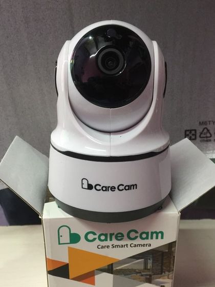 The Care Cam smart camera, unboxed and ready for setup. This model is designed for easy mobile phone network access, allowing you to monitor your home remotely.