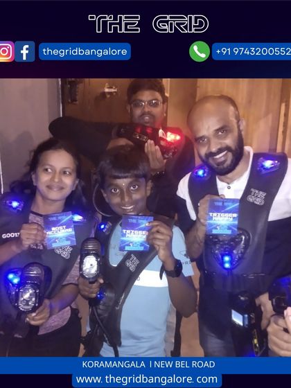 A family shows off their score cards after a fun game of laser tag together.