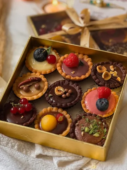 Another view of the mini tartlettes box, highlighting the rich colors and textures of each individual tart. It's a sophisticated treat for a discerning sibling.