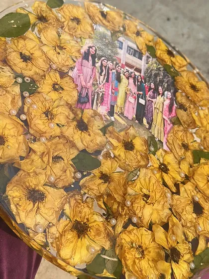 A close-up of the friendship frame, filled with bright yellow roses and a cherished group photo from a farewell day.