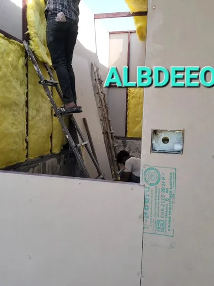 Our team installing glass wool insulation into the wall panels. This is a critical step to ensure every room we build is energy-efficient and comfortable.