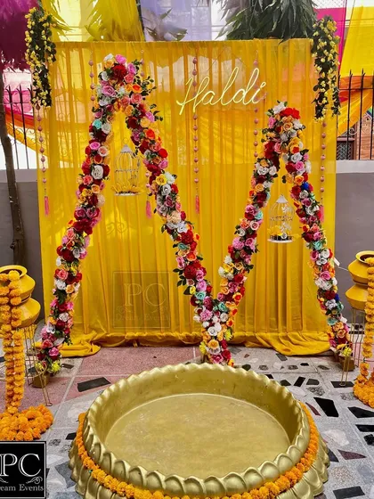 A close-up view of the floral arch and the Haldi seating area, highlighting the bird cages and other small details that I added to the decor.