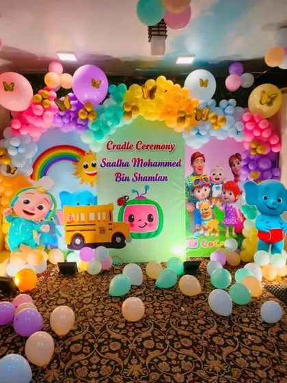 A colorful Cocomelon-themed Cradle Ceremony decoration. This full-room setup includes a large backdrop, character cutouts, and a vibrant balloon arch to celebrate the special day.
