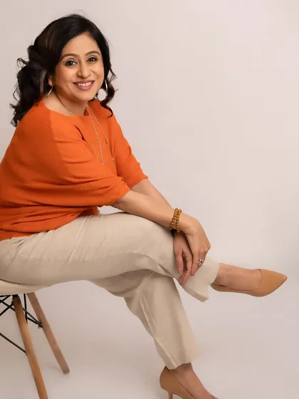 This portrait captures such a calm and positive energy. We used a simple, bright background to complement her orange top, creating a headshot that feels both warm and professional.
