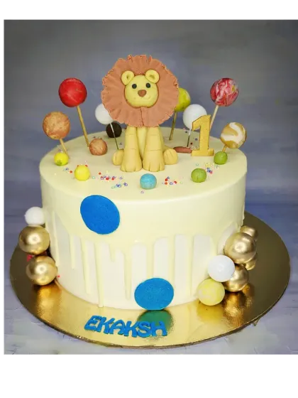 A modern and playful take on the lion theme for a first birthday. This eggless choco-vanilla cake features a handmade fondant lion and colorful lollipops.