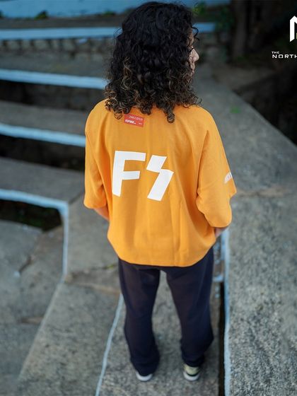 A back view of the Flypside orange tee, showing how the large 'FS' graphic looks when worn.