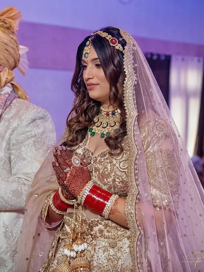 A radiant dawn for a glowing bride. Simran's ivory and gold lehenga was paired with soft, luminous makeup and a colorful matha patti for a unique and modern bridal look.