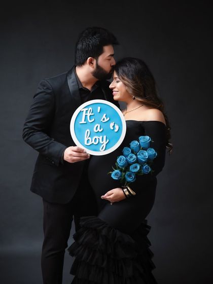 Announcing a baby boy with a beautiful bouquet of blue roses and a sign. This is a classic and elegant way to do a gender reveal during your maternity shoot.