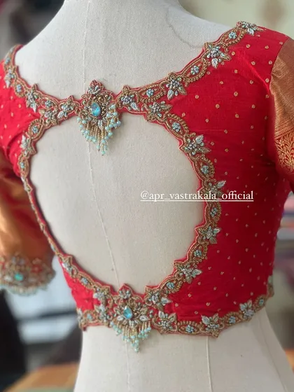 We love adding unique details, like this elegant heart-shaped cutout on a bridal blouse. The intricate zardosi and stone work framing the back adds a touch of modern romance to a traditional design.