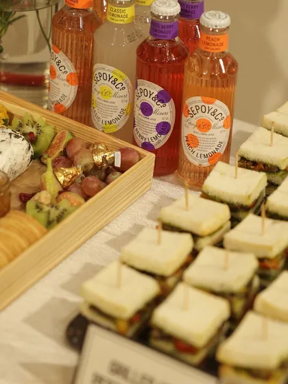 This spread for a brand event showcases my attention to detail. I pair my food offerings, like these fresh finger sandwiches and cheese platters, with complementary beverages to provide a complete and cohesive catering experience.