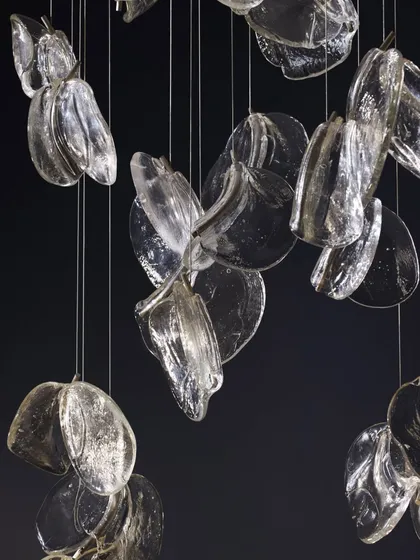 A studio shot of the Bocci 141 series against a black background, highlighting the intricate details and unique shapes of each pendant.