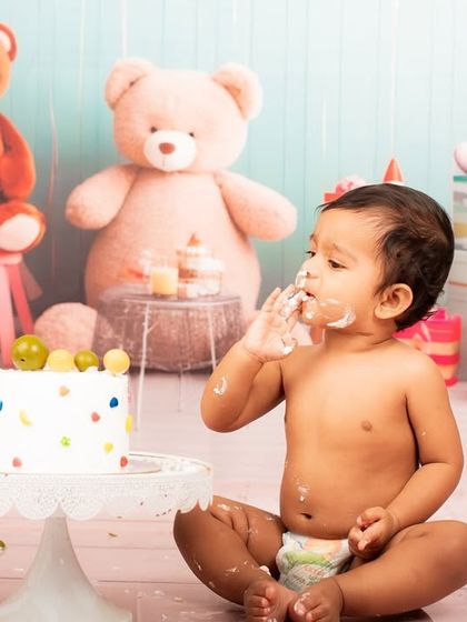 Getting right into it. This little one is enjoying every bit of his cake, a perfect example of the messy fun we capture in a cake smash session.