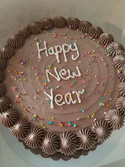 A simple chocolate cake with colorful sprinkles, perfect for a New Year's celebration.