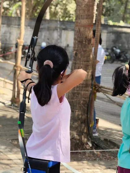 A young girl at full draw, demonstrating the strength and control we help our students develop.