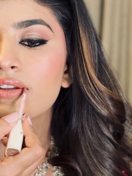 A close-up shot of the lip application for this gorgeous look. The focus is on creating a perfectly defined, glossy lip that complements the soft glam eye makeup.