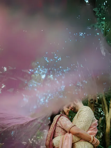 A truly magical moment created with a pink smoke effect, enveloping the couple in a cloud of color. This shows how we can use creative elements to add a touch of fantasy to your outdoor pre-wedding shoot.