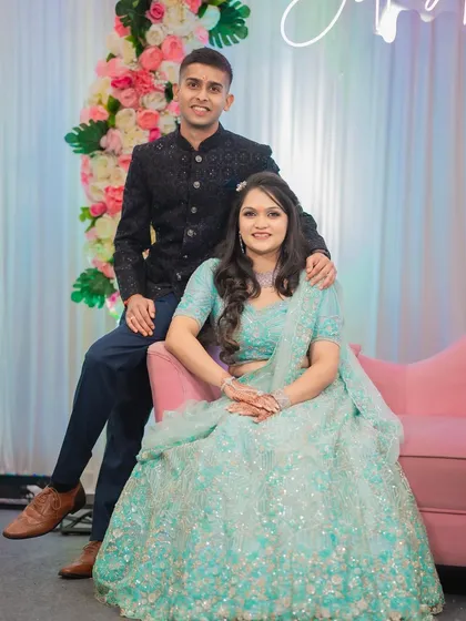 A formal portrait of Diksha and Vighnesh at their engagement ceremony. This photo showcases their coordinated outfits and the elegant decor of their event.