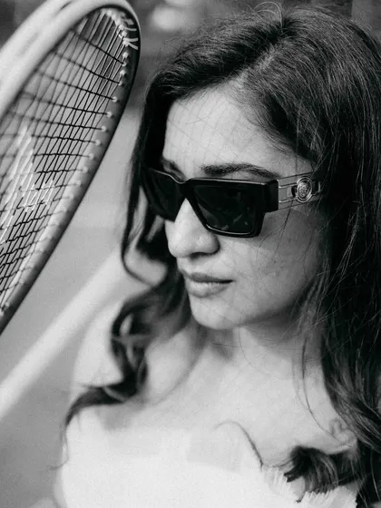 A chic, black and white portrait from the tennis court series. The close-up on her stylish sunglasses and the tennis racket adds a fashionable and sporty element to the pre-wedding gallery.