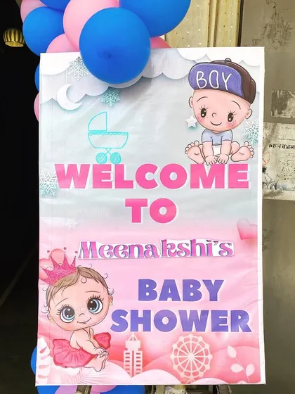 A custom welcome board for Meenakshi's baby shower, with cute "boy or girl" graphics.