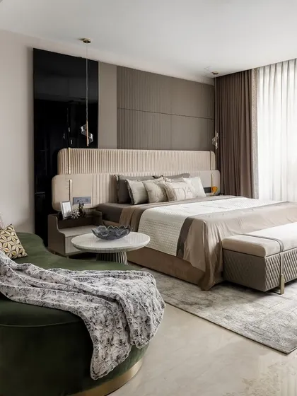 This son's bedroom is a personal retreat, layering soft neutrals with plush textures. A deep green curved lounger provides a bold, grounding contrast and a comfortable spot for relaxing.