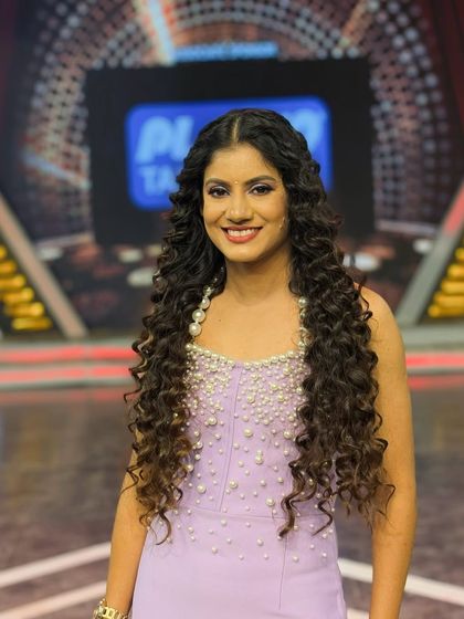 A close-up portrait from a TV appearance, showcasing the detailed pearl work on the gown. Attention to detail in styling is crucial for on-camera work.