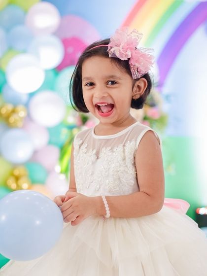 The pure joy of a special day. This little one is wearing a custom white gown with an illusion neckline and lace applique, perfect for a birthday or as a flower girl dress.