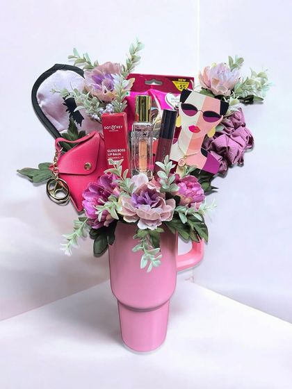 A fun and stylish gift for her, creatively arranged inside a large pink tumbler. This hamper is packed with beauty items, a coin pouch, and other accessories.