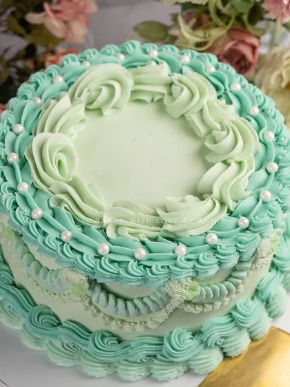 I am obsessed with bringing back classic designs. This cake features intricate, vintage-style Lambeth piping in a beautiful Tiffany blue buttercream over a rich dark chocolate ganache cake. It's elegance you can eat.