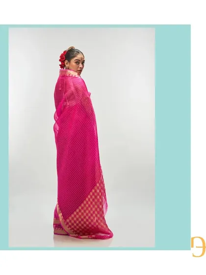 A back view of the vivid cerise saree, highlighting the striking color and the geometric play of the gold zari checks.