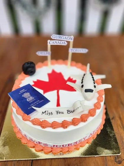 Another farewell cake, this time for a brother moving to Canada. The design includes a passport, a plane, and the Canadian maple leaf.