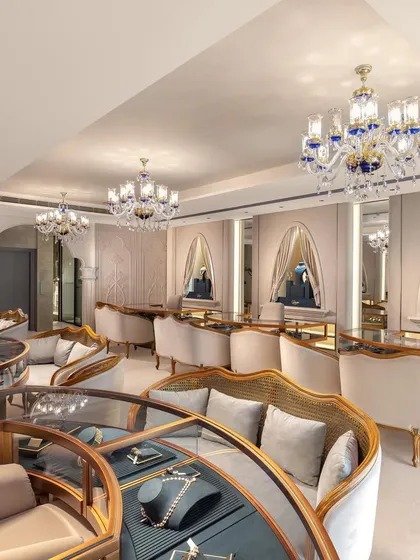 The showroom features custom-designed, curved seating and display counters that encourage intimate consultations. This layout, combined with ornate chandeliers, ensures a luxurious and comfortable experience for every customer.