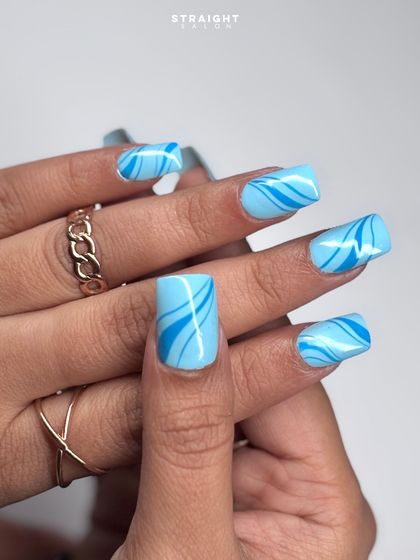 A playful and graphic design featuring hand-painted blue swirls on a light blue base. This look is fun, modern, and perfect for adding a pop of color.