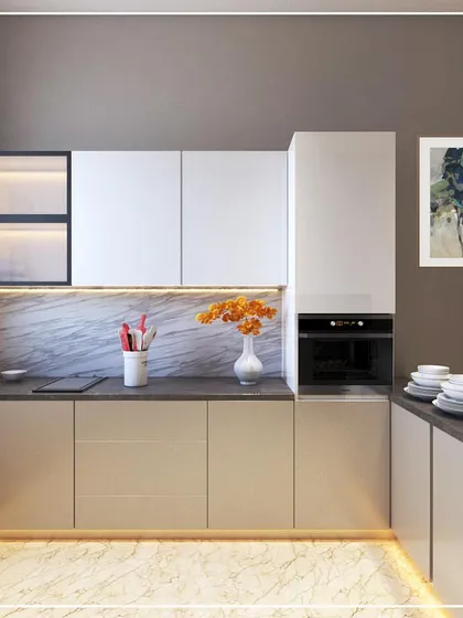 A kitchen design option for a project in Sonipat, Haryana. It combines beige and white cabinets, a dark countertop, and a marble-patterned backsplash, with backlit glass cabinets for display.