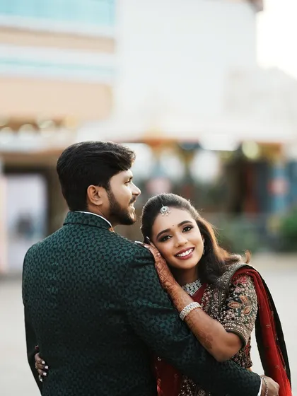 A stunning portrait of Dr. Saruna, resting her head on her groom's shoulder. Her makeup is flawless, and her expression is full of love and happiness.