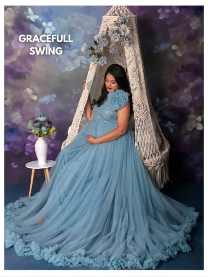 The Graceful Swing setup is perfect for creating fairytale-like portraits. Here, the mama-to-be looks ethereal in a flowing blue gown against a dreamy, painted backdrop.