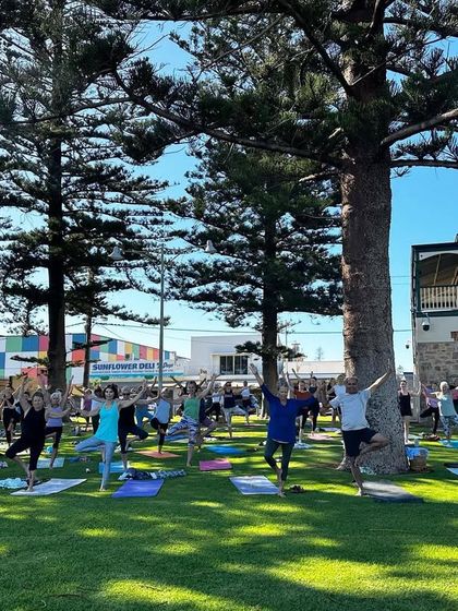 Another view of our community yoga session, with everyone finding their balance and focus together under the trees.