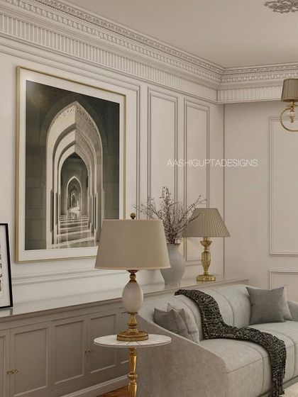 A tonal palette with a pop of texture defines this living area. The intricate mouldings on the walls and ceiling provide a classical canvas for the contemporary furniture and art, creating a balanced and timeless design.