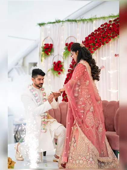 A romantic engagement moment. We created this beautiful backdrop with an arch of fresh red roses and delicate fairy lights to make the proposal extra special.