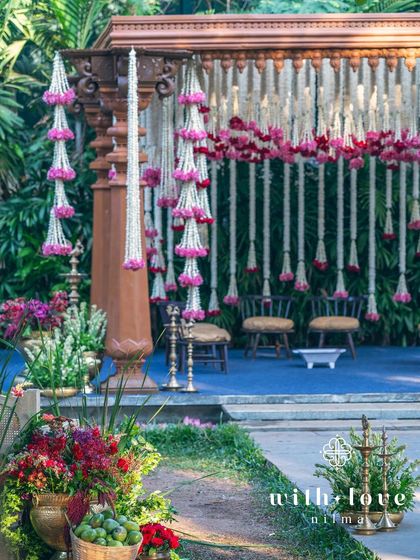 A view of the summer wedding mandap, with its beautiful floral garlands and traditional brass lamps.