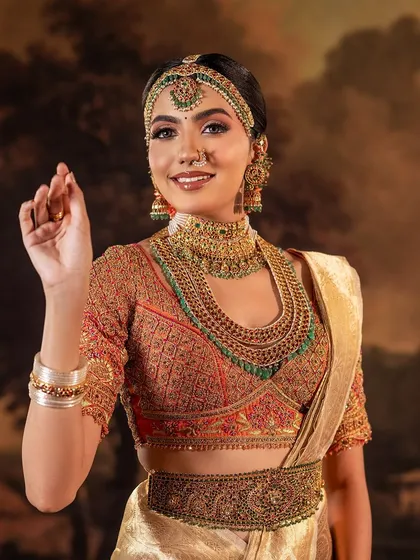 A full view of a bride's custom blouse, showcasing the dense and detailed embroidery work. The design incorporates traditional motifs with a vibrant color palette for a truly unique piece.
